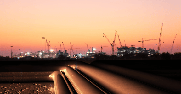 Natural gas pipeline with sunset and gathering equipment in the background