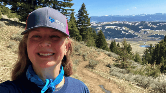 Data Processor Elizabeth Desser smiling on a hike with mountains in the background