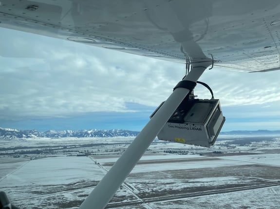Gas Mapping Lidar device attached to a plane with snowy mountains in background