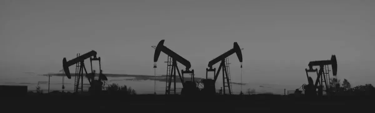 Black and white oil field image with four oil drills